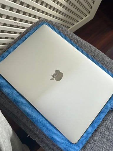 An apple laptop is sitting on a chair